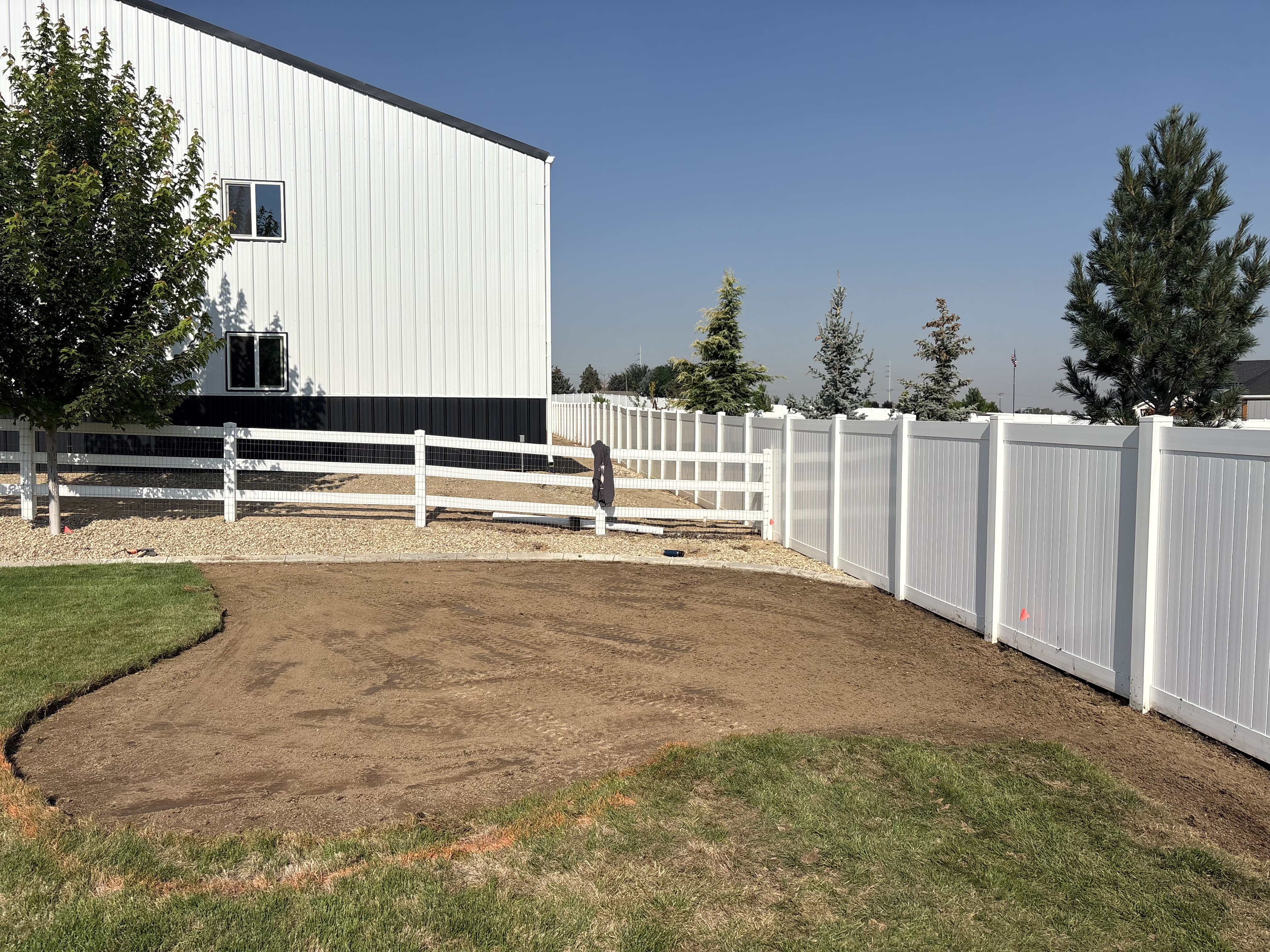 Project 04 backyard before landscaping work began, with new vinyl fencing and unfinished dirt patio area